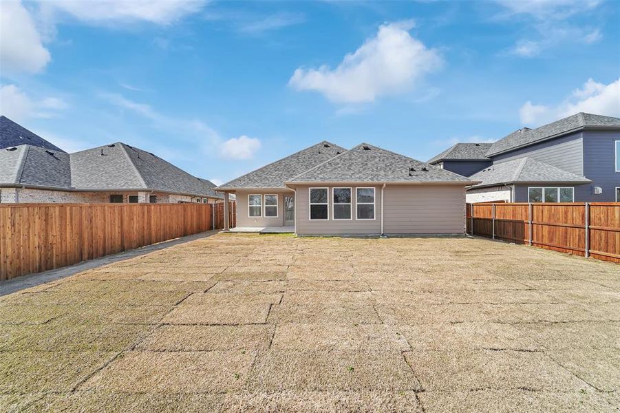 Rear view of house featuring roof with shingles, a lawn, and a fenced backyard Rear view of house featuring roof with shingles, a lawn, and a fenced backyard