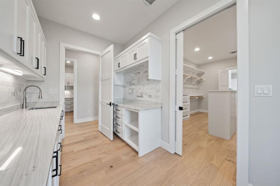 Large utility room off the main closet with sink and tons of storage. Across from this is the pantry.