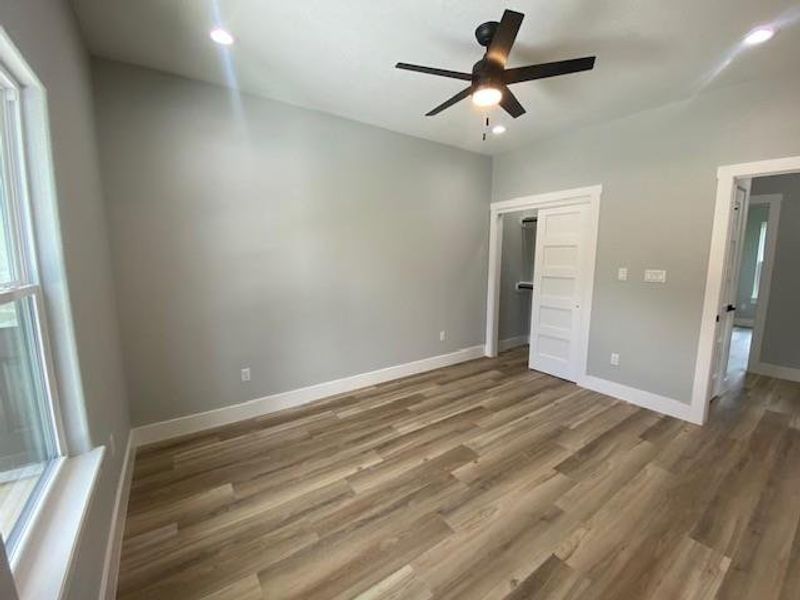 Well-lit sleeping quarters with a ceiling fan and elegant wood flooring, ready for personalization. Well-lit sleeping quarters with a ceiling fan and elegant wood flooring, ready for personalization.