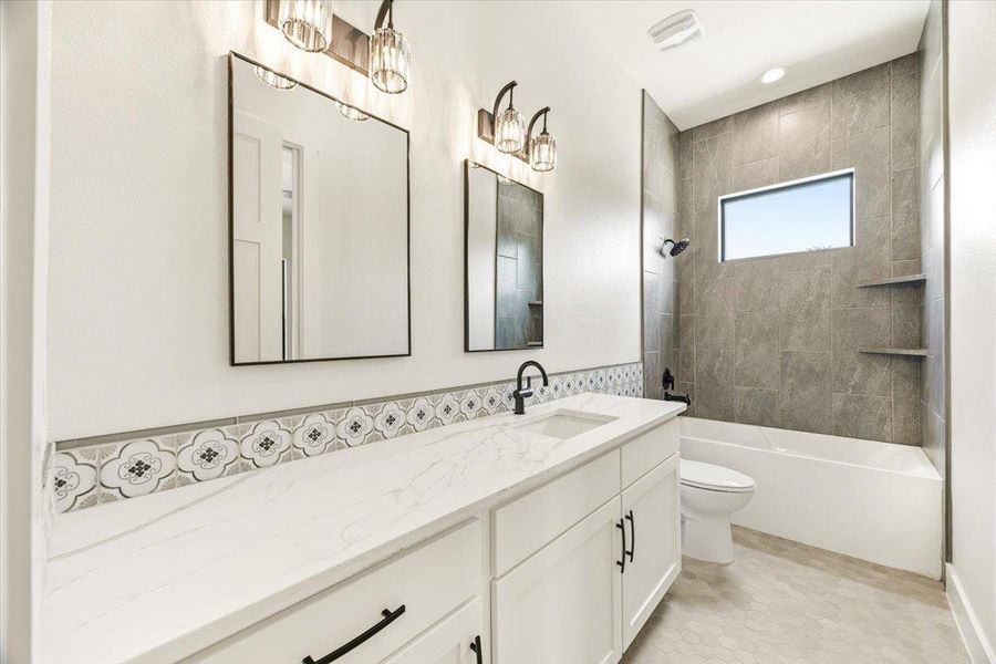 A well-lit primary bathroom featuring a double vanity and a shower-tub combo with a window.