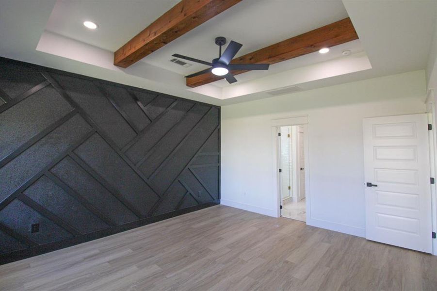 Unfurnished bedroom featuring wood finished floors, a ceiling fan, beam ceiling, recessed lighting, and a raised ceiling Unfurnished bedroom featuring wood finished floors, a ceiling fan, beam ceiling, recessed lighting, and a raised ceiling