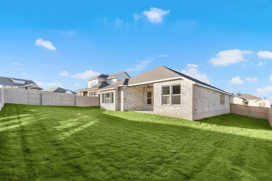 Rear view of house with a patio area, a fenced backyard, brick siding, and a ceiling fan Rear view of house with a patio area, a fenced backyard, brick siding, and a ceiling fan