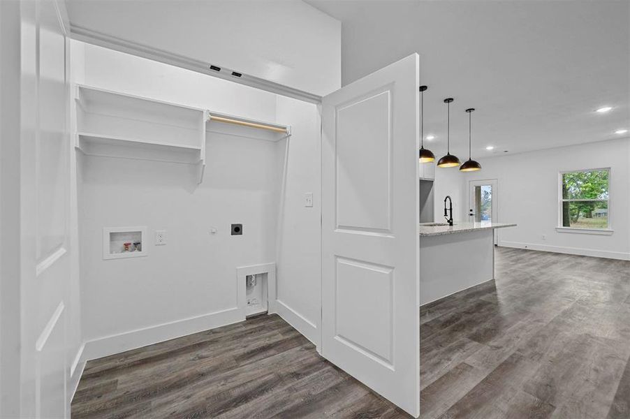 Laundry area featuring dark hardwood / wood-style floors, sink, electric dryer hookup, hookup for a gas dryer, and washer hookup