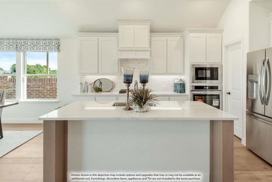 Kitchen with white cabinets, large center island, quartz countertops, and stainless steel appliances