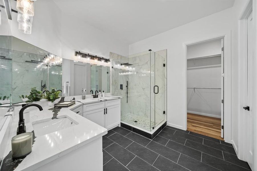 Bathroom featuring tile patterned floors, dual bowl vanity, and walk in shower