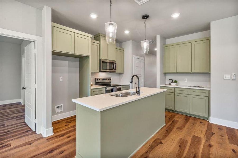 Kitchen featuring green cabinetry, hanging light fixtures, appliances with stainless steel finishes, dark wood finished floors, and recessed lighting Kitchen featuring green cabinetry, hanging light fixtures, appliances with stainless steel finishes, dark wood finished floors, and recessed lighting
