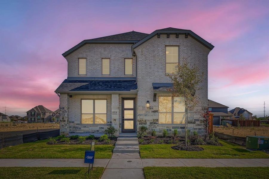 View of front of home featuring a shingled roof, brick siding, and stone siding