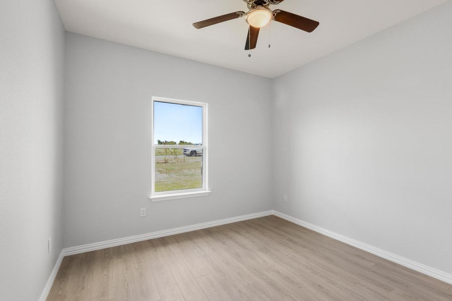 Spare room featuring light wood-type flooring and a ceiling fan Spare room featuring light wood-type flooring and a ceiling fan