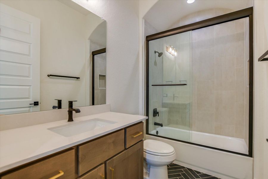 Bathroom with vanity, bath / shower combo with glass door, and tile patterned floors