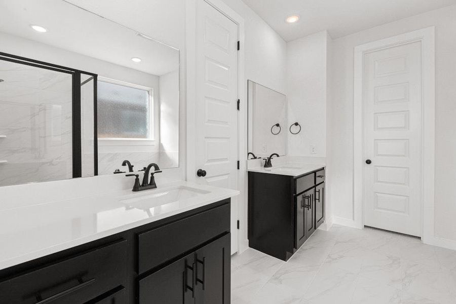 Bathroom featuring two vanities, light marble finish flooring, a marble finish shower, and recessed lighting Bathroom featuring two vanities, light marble finish flooring, a marble finish shower, and recessed lighting