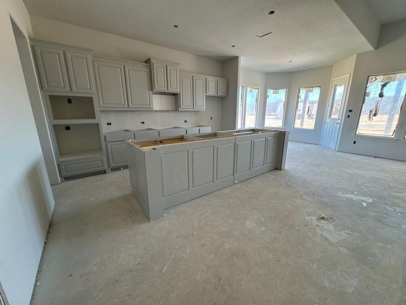 Kitchen with a center island and unfinished concrete flooring