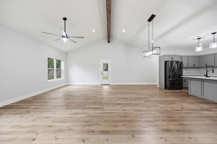 A spacious, open-concept interior featuring light wood flooring and vaulted ceilings, ready for personalized touches. A spacious, open-concept interior featuring light wood flooring and vaulted ceilings, ready for personalized touches.