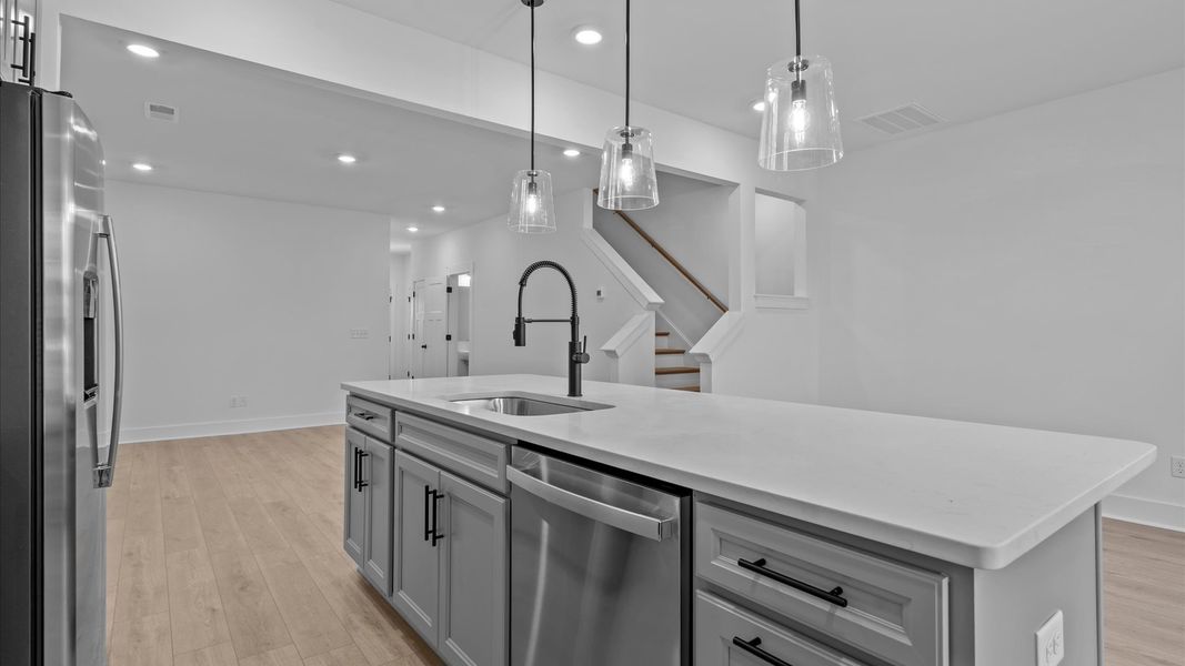 Tasteful design meets functional luxury in this kitchen with a 9-foot island and modern pendant lighting