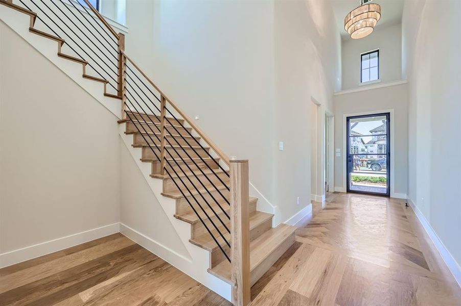 Entryway featuring an inviting chandelier and a towering ceiling