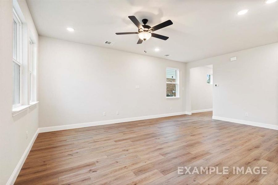 Empty room with ceiling fan and light hardwood / wood-style floors