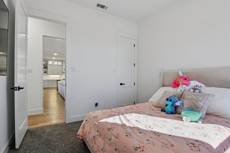 Bedroom featuring dark colored carpet and baseboards Bedroom featuring dark colored carpet and baseboards