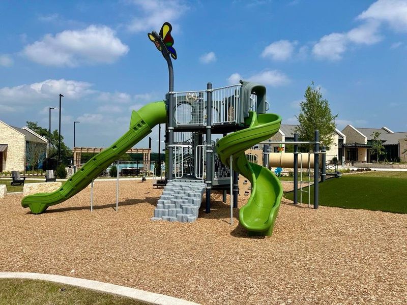 Outdoor play structure featuring multiple slides, climbing elements, and a butterfly accent