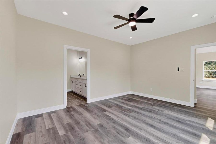 Unfurnished bedroom featuring light wood-type flooring, a ceiling fan, connected bathroom, and recessed lighting Unfurnished bedroom featuring light wood-type flooring, a ceiling fan, connected bathroom, and recessed lighting