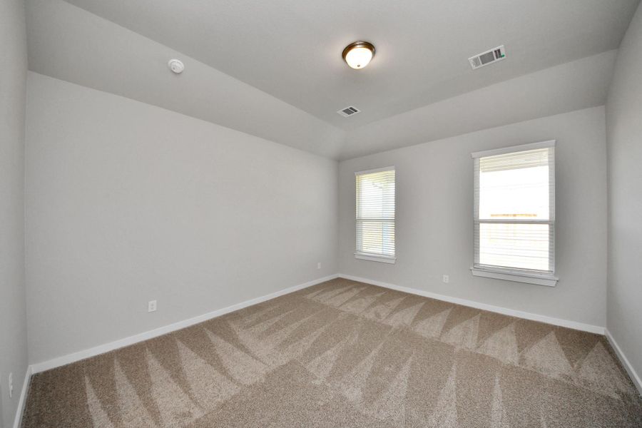 Escape and relax in the exquisite primary suite, a haven to unwind after a long day. The spacious room, located on first floor, boasts plush carpeting, soothing paint tones, high ceilings, and expansive windows adorned with privacy blinds. Sample photo of completed home with similar floor plan. Actual colors and selections may vary. Escape and relax in the exquisite primary suite, a haven to unwind after a long day. The spacious room, located on first floor, boasts plush carpeting, soothing paint tones, high ceilings, and expansive windows adorned with privacy blinds. Sample photo of completed home with similar floor plan. Actual colors and selections may vary.