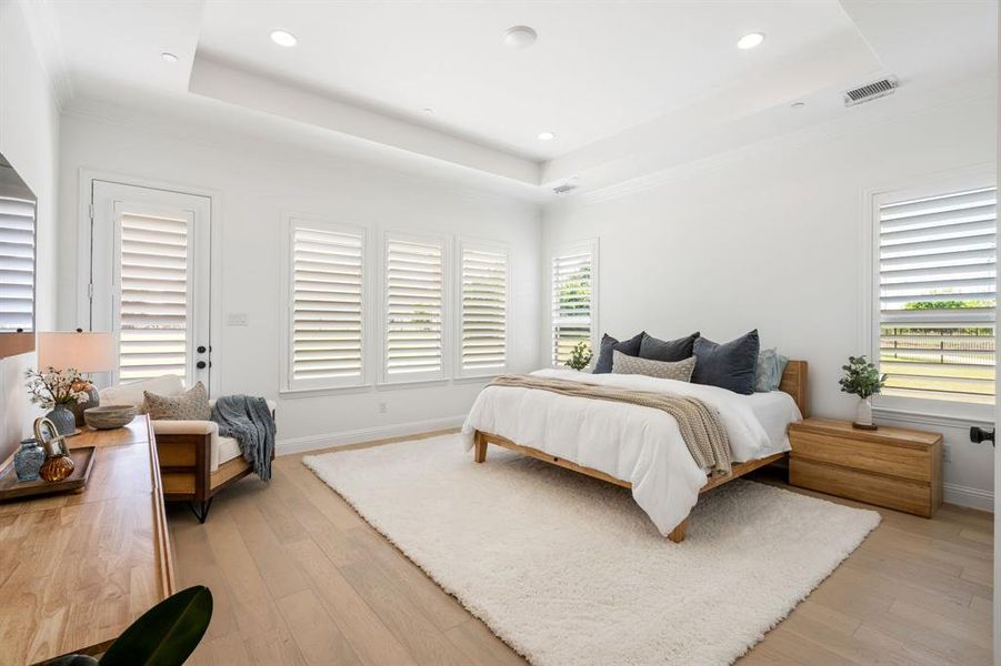 The primary bedroom serves as a personal retreat, blending indoor comfort with a private outdoor patio.