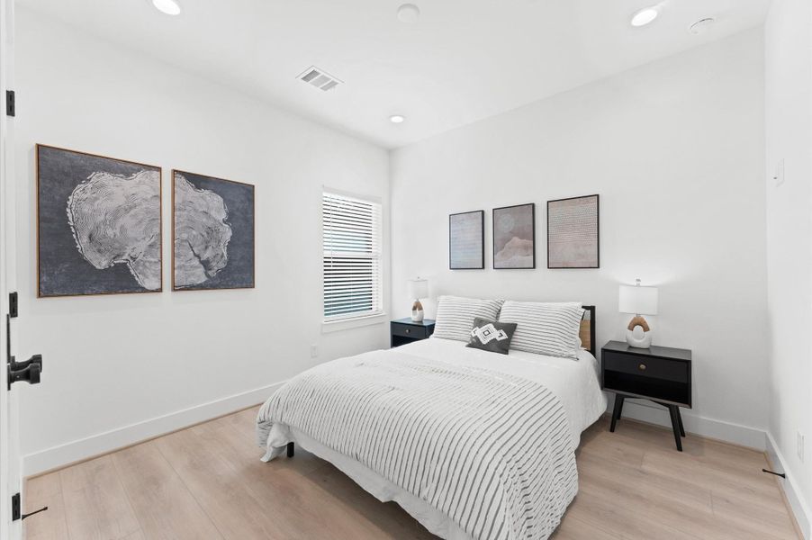 Modern townhomes with sleek black and white exteriors, featuring large windows and private balconies, set in a well-maintained neighborhood.