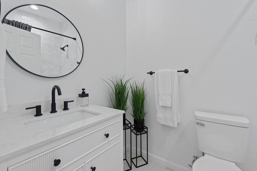 Bathroom featuring vanity, a tile shower, and tile patterned flooring