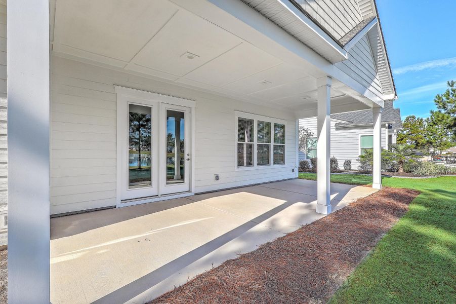 Exterior details and patio area of a home in K. Hovnanian's® Four Seasons at Lakes of Cane Bay, Summerville (Image 20).