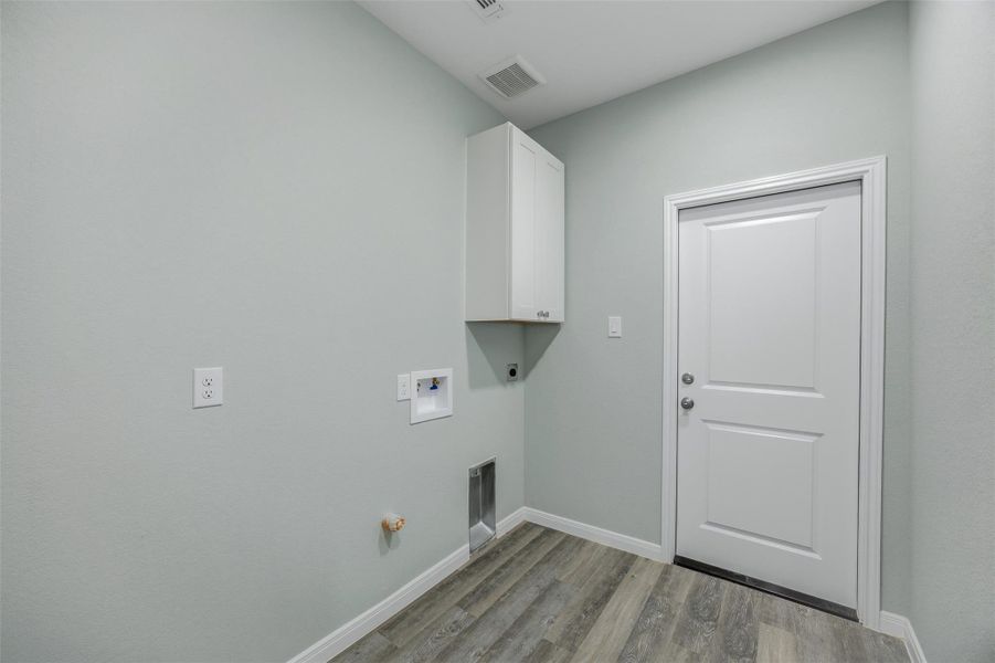 Functional utility room with ample space for laundry appliances and storage.