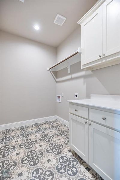 Laundry area with electric dryer hookup, washer hookup, recessed lighting, cabinet space, and ceramic tile floors