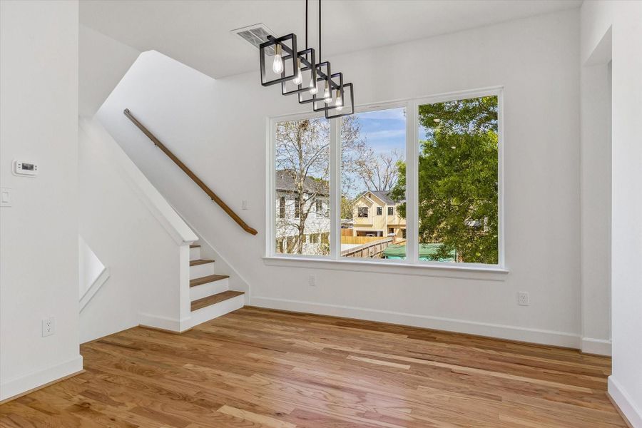 Upon ascending to the second floor, you are welcomed by an open-concept layout that flows seamlessly into the dining area, elegantly illuminated by a modern chandelier. Upon ascending to the second floor, you are welcomed by an open-concept layout that flows seamlessly into the dining area, elegantly illuminated by a modern chandelier.