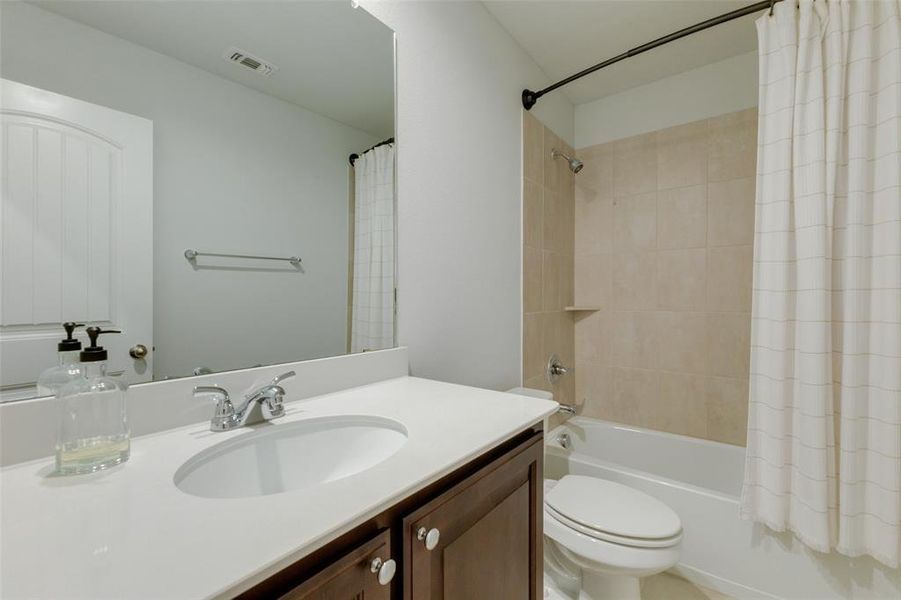 Full bathroom with shower / bath combo, toilet, and vanity