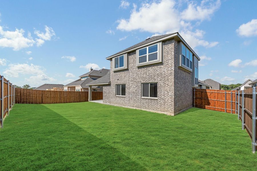 Two-story brick home with large grassy backyard and wood privacy fence Two-story brick home with large grassy backyard and wood privacy fence