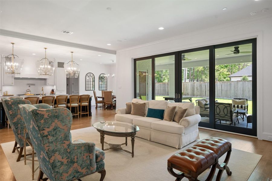 Views of the living room showcase a bright, open space with large windows that flood the room with natural light.