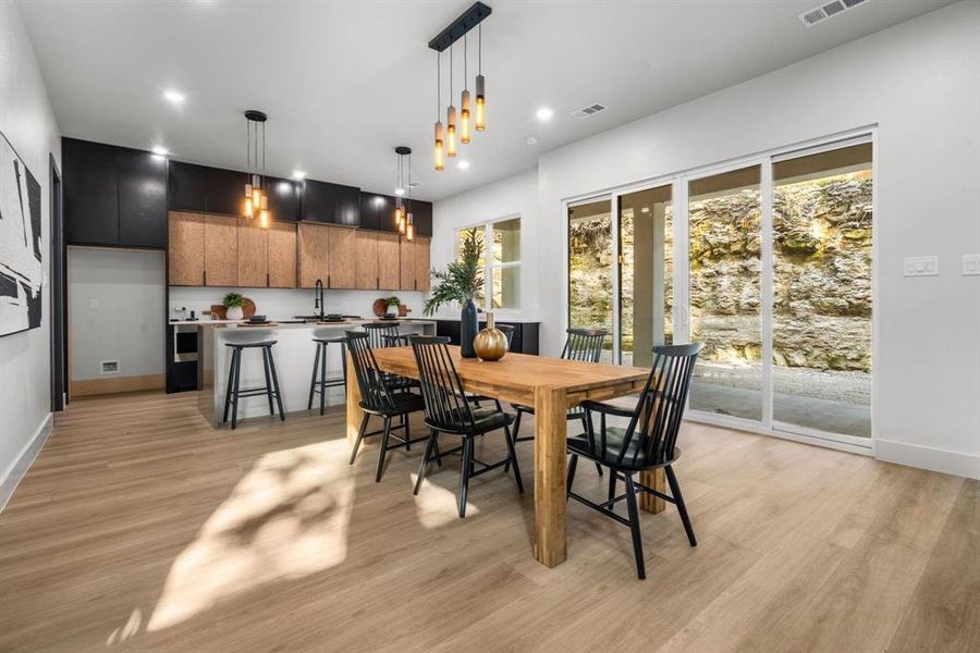 Dining area with light wood-style floors and recessed lighting