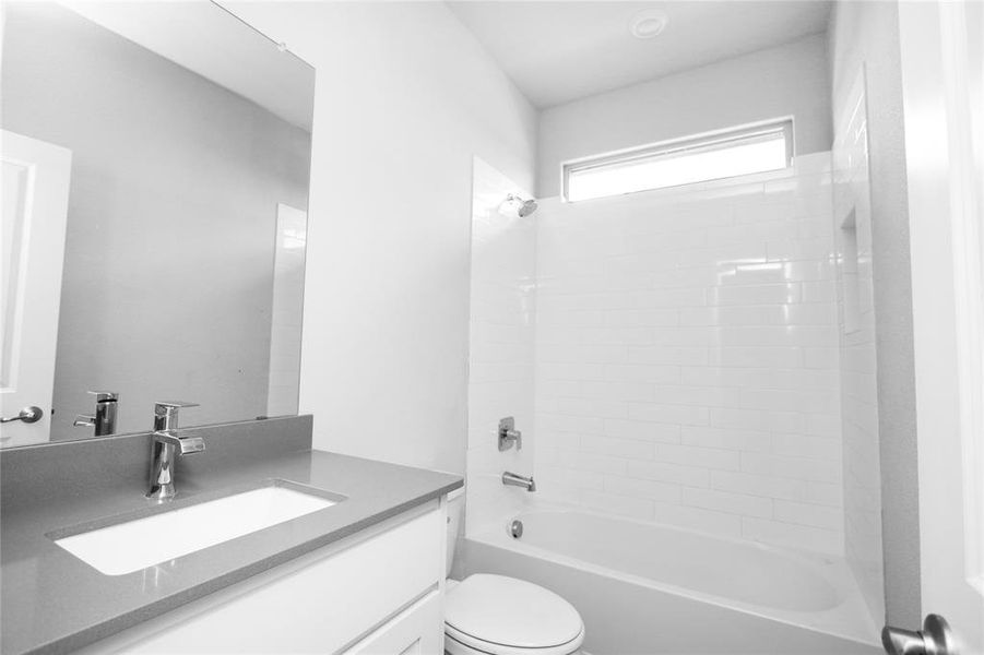 Full bathroom with vanity, toilet, and tiled shower / bath combo