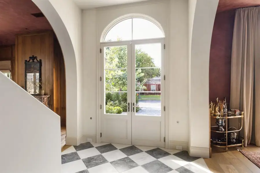 Entryway featuring arched walkways, french doors, and tile patterned floors