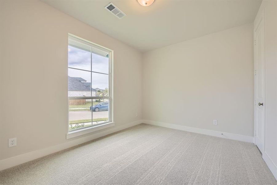 Empty room with light colored carpet and baseboards