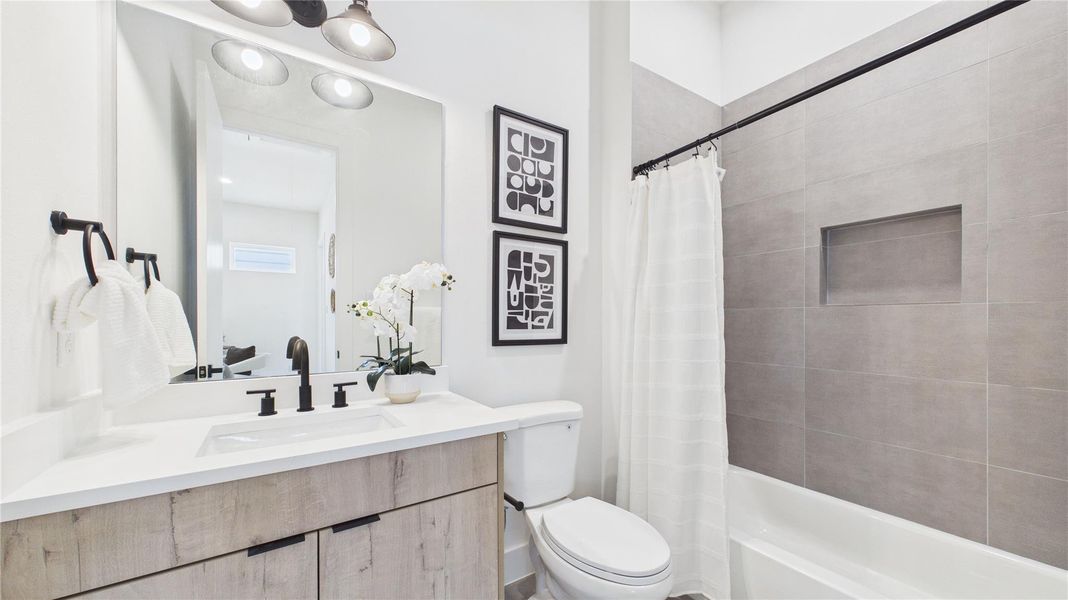The secondary bathroom upstairs is adorned with tiling and a soap nook in the bath/shower combination. The quartz vanity and large mirror provide the area needed to get ready for the day!