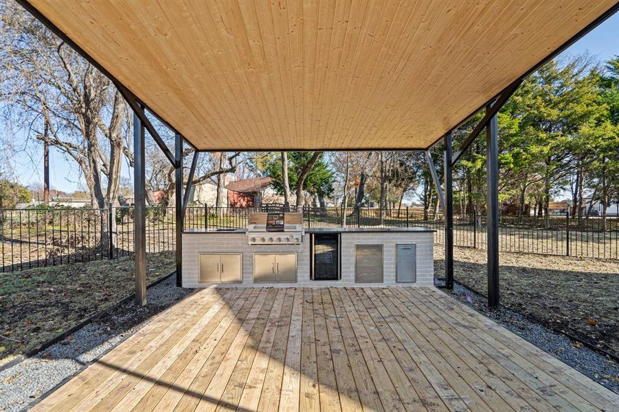 Wooden deck featuring an outdoor kitchen and area for grilling