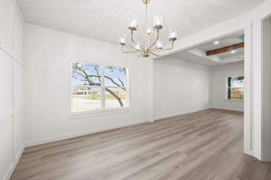 A graceful chandelier illuminates the living area with fresh flooring and abundant natural light. A graceful chandelier illuminates the living area with fresh flooring and abundant natural light.