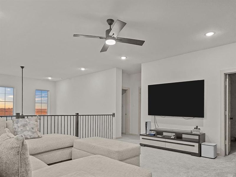 Living room featuring ceiling fan and light colored carpet