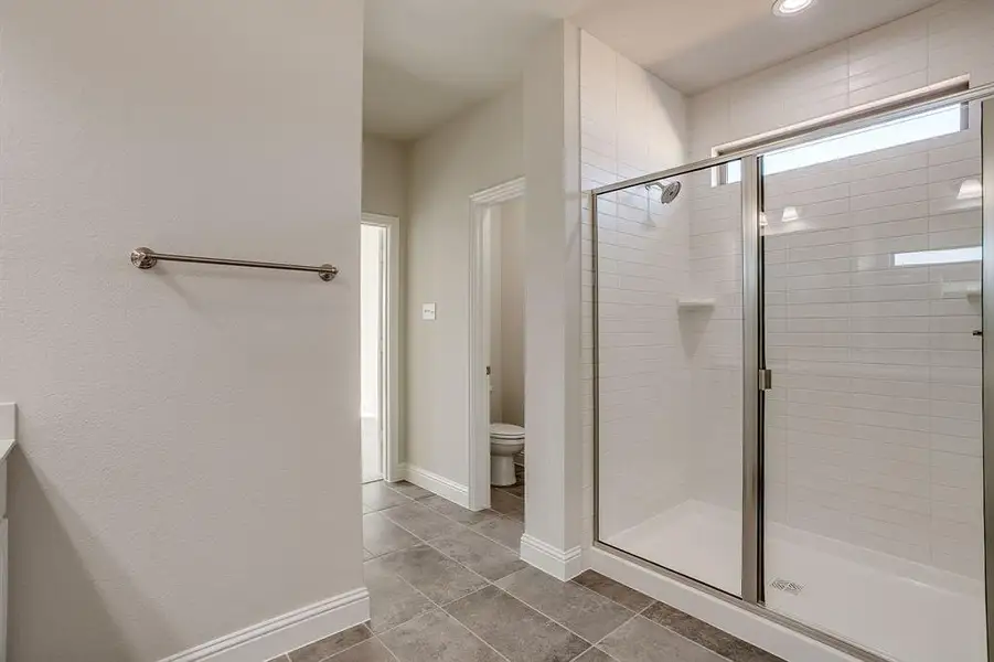 Full bath featuring a shower stall, vanity, and light tile patterned floors