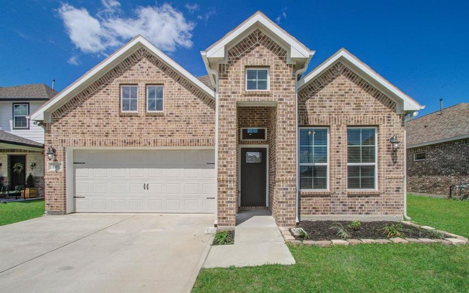 This is a modern single-family home featuring a brick facade, two-story design with an attached two-car garage, and a double car driveway front yard.