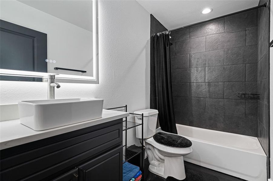 Full bathroom with vanity, toilet, and shower / tub combo