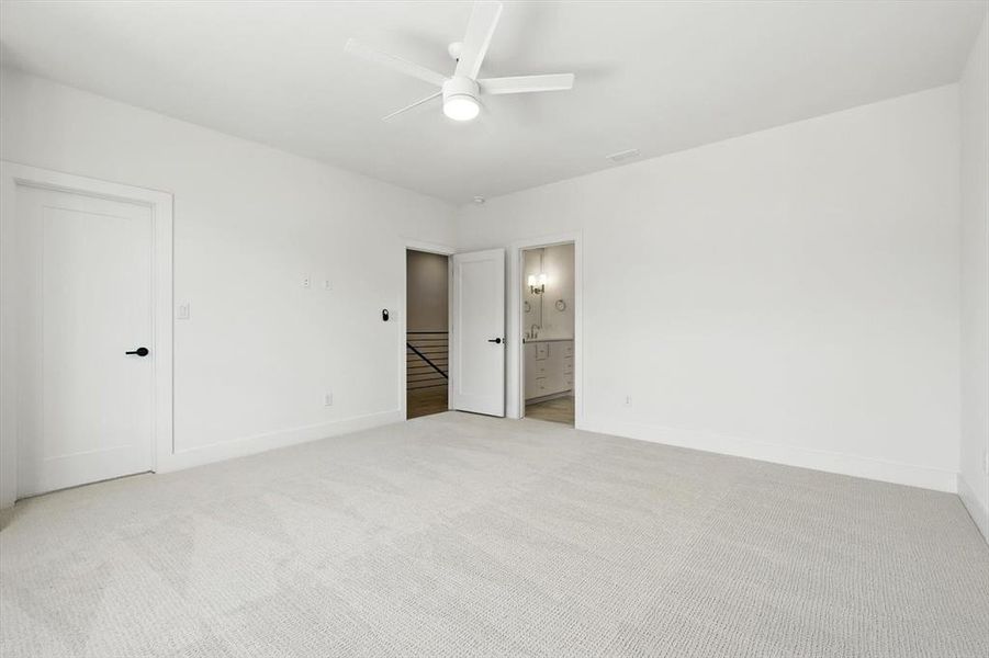 Unfurnished bedroom with light carpet, a ceiling fan, and connected bathroom Unfurnished bedroom with light carpet, a ceiling fan, and connected bathroom