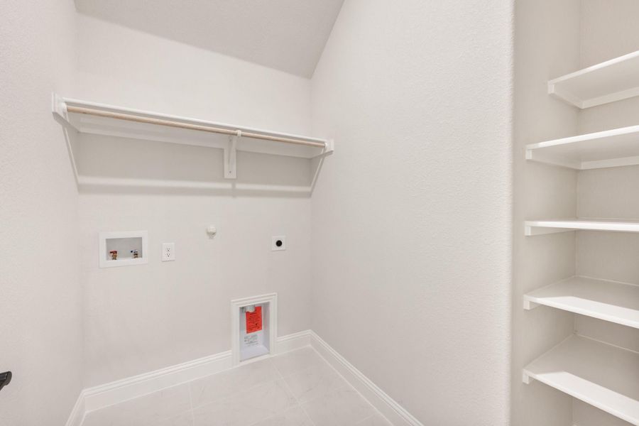 Laundry room with washer and dryer hookups, hanging rod, and built-in white shelving unit