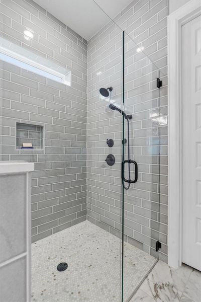 Walk-in glass shower with insert for soap/shampoo and a seat to one side. Walk-in glass shower with insert for soap/shampoo and a seat to one side.