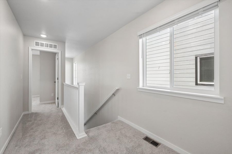 A room with a window and a staircase.