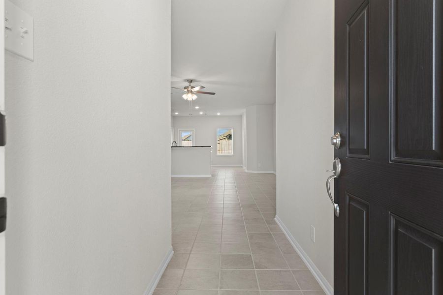Step inside to a bright, open foyer that instantly feels fresh and welcoming. The neutral large tile flooring flows seamlessly throughout, guiding you toward the home’s open concept living spaces filled with natural light.