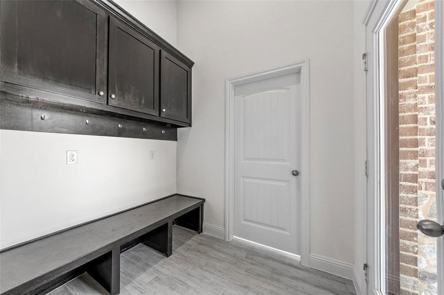 Mudroom with light wood-style floors and baseboards